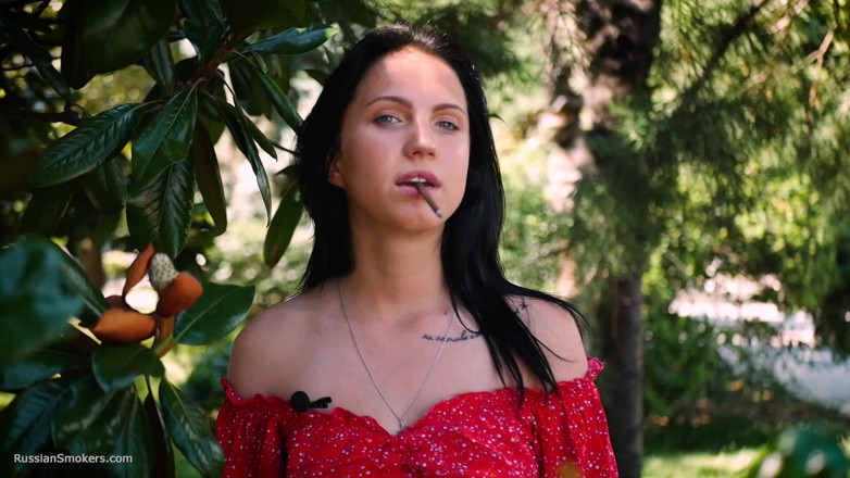 Russian Smokers: Une brune sensueuse en robe rouge fume une cigarette roulée