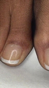 La ragazza ebano mostra il suo pedicure francese nelle sue calze nere e fa rimozione per mostrare i suoi piedi