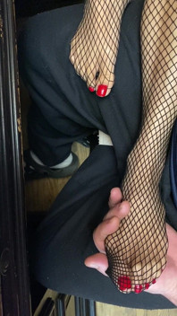 Pequeños pies en medias de rejilla ... Uñas en los dedos rojos