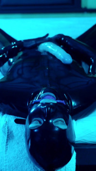 Tied up rubber girl in catsuit fucking herself