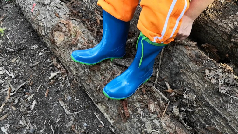 Bouncy Tits Action: Sitting in rubberboots on woodpile