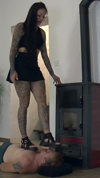 Paní Cleo stojí na svém otroku a kouří
