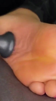 Ebony Girl Gives Her Feet a Massage with a Massage Gun