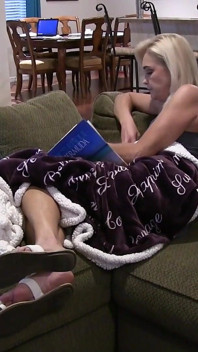 Elle lit et repose ses pieds sexy