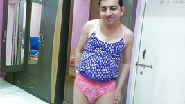 Si banci crossdresser femboy Sweet Lollipop di atas tank top, celana dalam dan sandal jepit dengan lipstik.