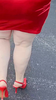 Une belle femme marche dehors sur un parking s’exhibe devant des inconnus