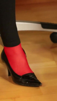 Medias rojas y tacón de pata debajo de las polainas