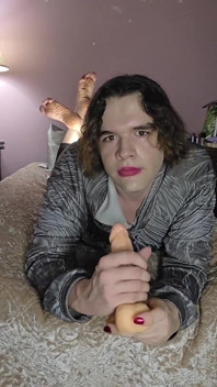Niebinary femboy wykonuje trening gardła podczas pozy