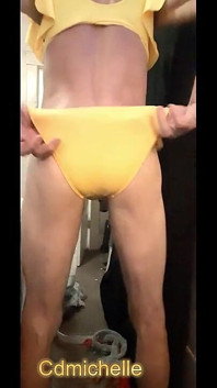 Travestito indossa l'abbronzatura sexy ed un costume da bagno giallo