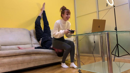 Petite Princesses Femdom: レギンスを着たゲーマーキラは、プレイ中に椅子の奴隷を使用します