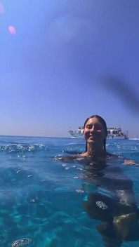 Atemberaubendes mädchen schwimmt nackt am öffentlichen strand