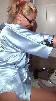 Chubby Blonde with Skyblue Bathrobe Pisses Masked Guy in Mouth