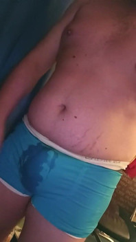 Băiat dolofan se pișă în undies alb și albastru