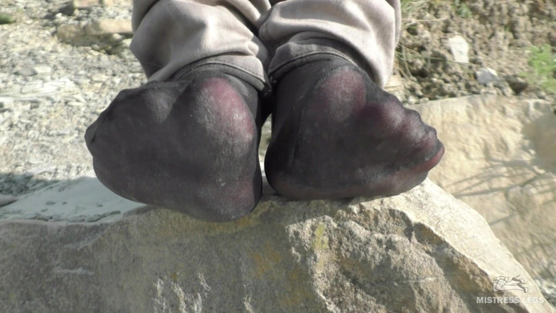 Mistress Legs: Jeans feet in black nylon socks on the seashore