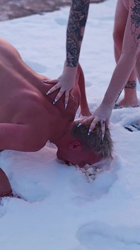 Femdom. Due donne tettone piscino nude nella neve, poi fanno mangiare un ragazzo nudo e leccano la neve gialla.