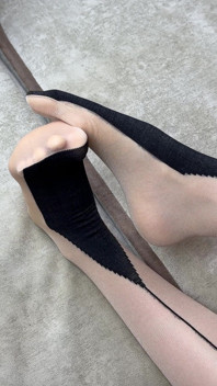 Ensam smekande långa ben i svart nylon strumpbyxor