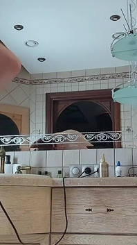 Eine charmante frau preening im Badezimmer vor einem spiegel