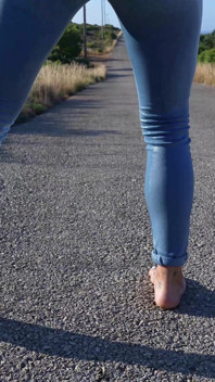 Bagnando i jeans su un'escursione a piedi nudi
