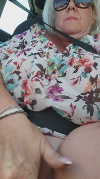 Зріла блондинка пестить пальцями пульсуючу пизду в громадській їзді на машині