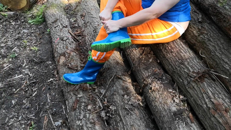 Bouncy Tits Action: Sitting in rubberboots on woodpile