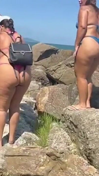 텅 빈 해변을 따라 끈 비키니를 입은 뜨거운 갈색 머리 여성들이 맛있다