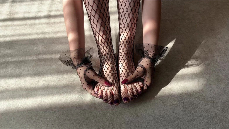 Gloria Gimson: Meisje streelt haar benen in een zwarte visnetpanty