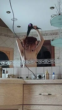 Une femme charmante se prépare dans la salle de bain devant un miroir