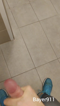 Un garçon blanc et mince se branle par portes ouvertes dans les toilettes de la salle de sport