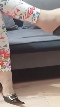 seksi kaale chamre men krosadresar jhoolte hue roja joote dvara pair ki anguli oonchi eri ke joote ki or ishaara kiya
