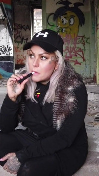 Blonde dame rookt een elektronische sigaret op de trap