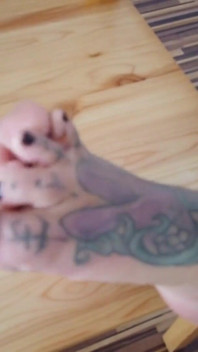 La signora bionda tatuata mostra i suoi piedi