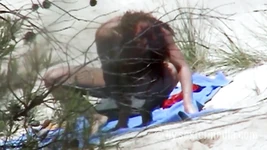 Redhead beauty dildoing pussy on the sandy beach