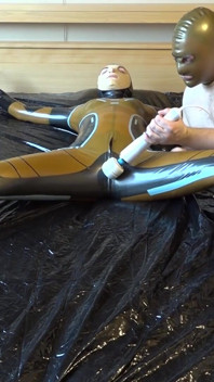 Latex Danielle wird am Bett befestigt und mit der massage mit dem vibrator masturbiert