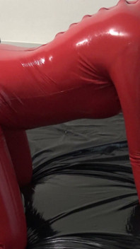 Sesión De Fotos En Catsuit De Látex Rojo Con Máscara De Látex Y Cara Transparente.