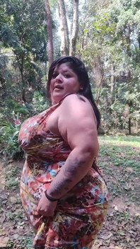 Femeie mare și țâțoasă își expune sânii mari în parc