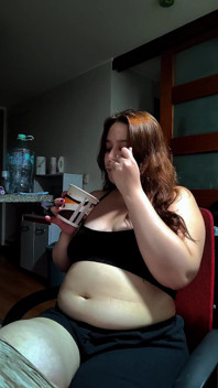 Calda donna paffuta riempie la sua pancia rotonda con alcuni dolci