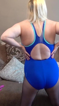 Bermain dengan dildo dalam pakaian renang biru dan pantyhose