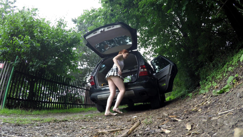 No panties TV: Une rousse sexy en jupe courte charge une voiture