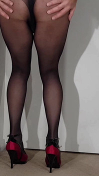 Décolleté rosso caldo e gambe formose in collant neri