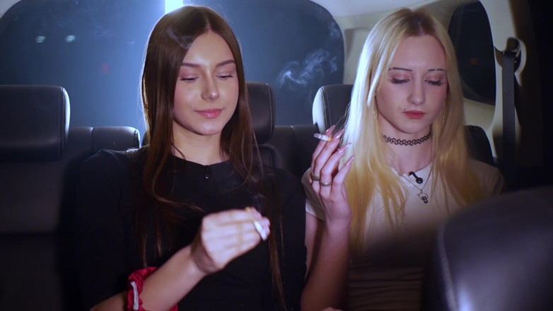 Russian Smokers: Zwei frauen rauchen und chatten in einem auto in der...