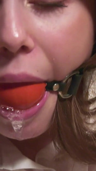 Leya è legata su una sedia e sbava attraverso ballgag