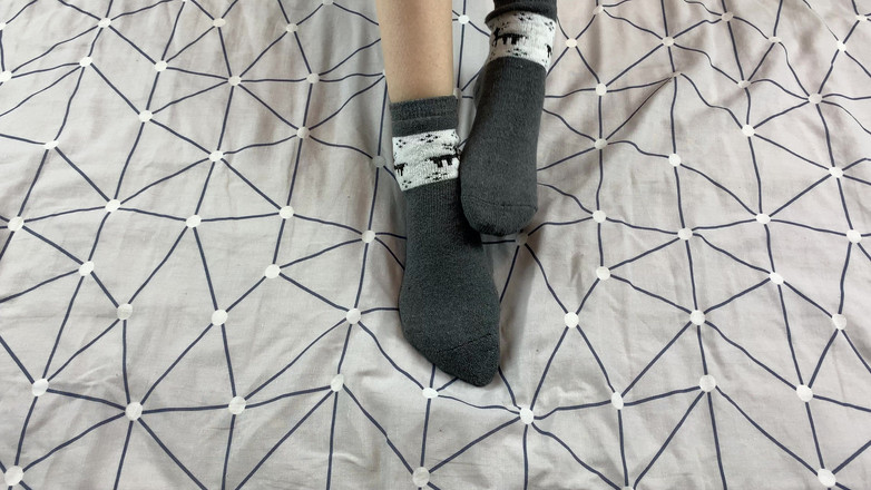 Gloria Gimson: O fată cu picioare lungi își mângâie picioarele în șosete gri de Anul...