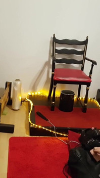 Kurvige brünette domina befiehlt gefesselten sklaven im fetisch-kerker