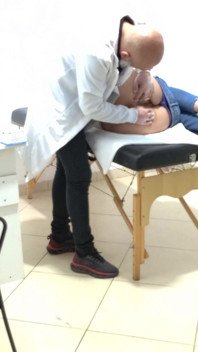 Proktolog provádí anální vyšetření kondomovaného pacienta