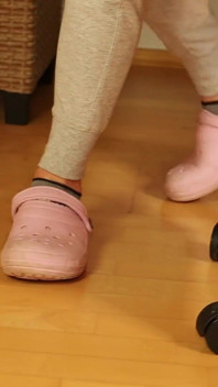 Des chaussettes grises coquines dans des sabots roses - taquinage des pieds décontracté