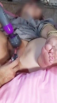 Sentada con las piernas cruzadas, haciéndola correrse con un vibrador.