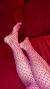 Opravdu sexy nohy s malými chodidly s dlouhými prsty v růžové síťovaných punčochách
