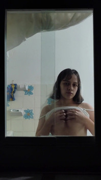 Ragazza latina filmata attraverso una finestra