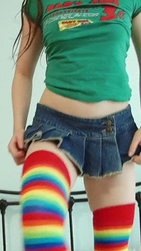 Ragazza pazza con calze colorate apre le gambe sul letto