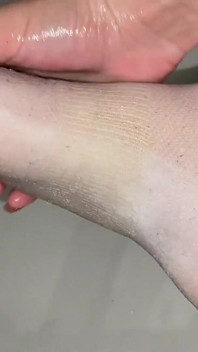 Massagem com óleo do pé em meias do tornozelo